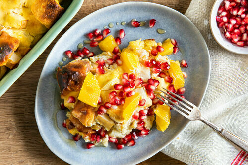 Süßer Brotpudding mit Ricotta und Birne garniert mit Granatapfel und Orange