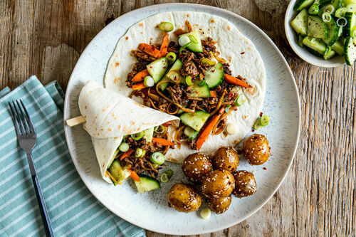 Asiatische Hackfleisch-Gemüse-Wraps mit Gurkensalat und pikanten Sesam-Kartoffeln