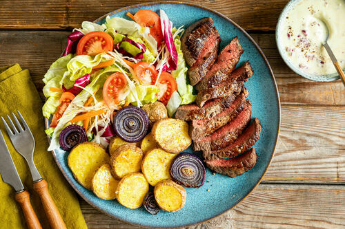 Rindersteak mit Röstkartoffeln dazu gemischter Salat und Joghurtdip