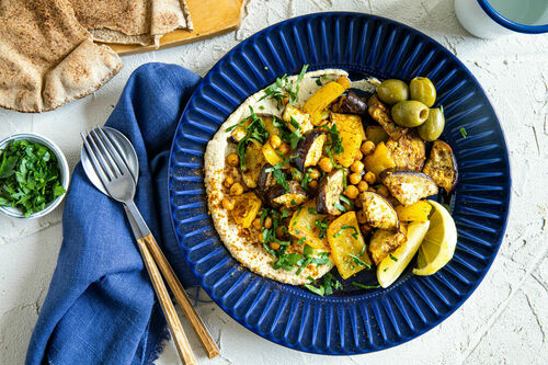 Hummus mit gegrilltem Gemüse dazu Oliven und warmes Vollkornfladenbrot