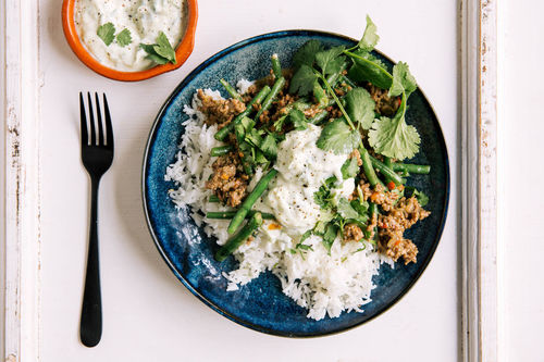 Schweinehack indische Art mit Bohnen, Reis und Gurkenraita