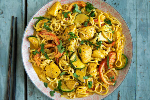 Thai-Nudelpfanne mit Hähnchen und gelber Kokosmilchsauce mit Gemüse