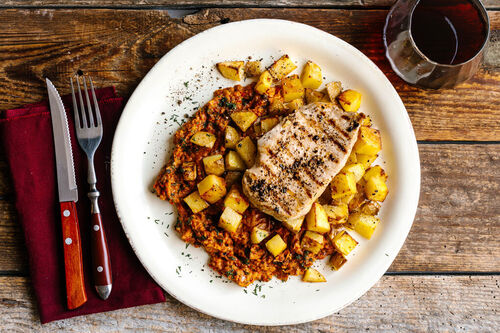 Gegrilltes Schweinerückensteak mit Ofenkartoffeln und Ajvar-Dip