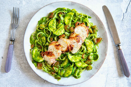 Hähnchen im Speckmantel auf Pasta mit Pesto, Zucchini und Tomate