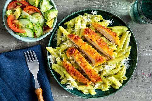 Zartes Hähnchenschnitzel und Salat an Pasta mit Avocado-Basilikum-Pesto