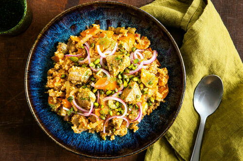 Fenchel-Karotten-Bulgur mit Schwein garniert mit roten Zwiebeln und Pistazien
