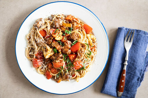 Pasta mit Rindfleisch-Pilz-Ragù garniert mit Basilikum und Käse