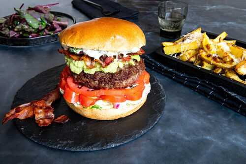 Bacon-Chipotle-Burger de luxe mit Käse-Trüffel-Pommes und Blattsenfsalat