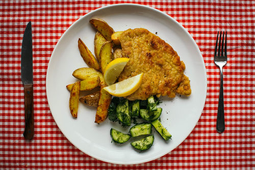 Schnitzel Wiener Art mit Gurkensalat und Backkartoffel