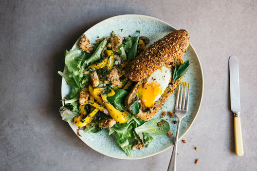 Überbackenes Baguette mit Ei und lauwarmen Paprika-Salat