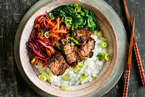 Teriyaki-Rindersteak mit Sesam auf Sushireis, dazu Rotkohlsalat und Spinat
