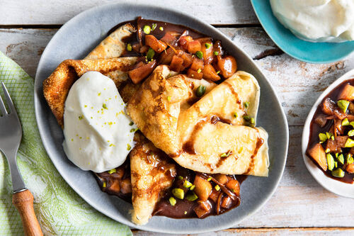 Crêpes mit Birnenkompott serviert mit Schlagsahne und Pistazien