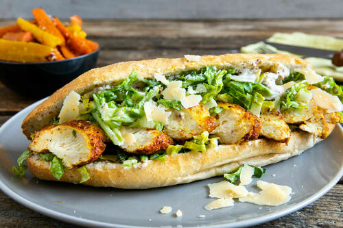 Hähnchensandwich mit Caesar-Salat dazu Karottenpommes mit Käse