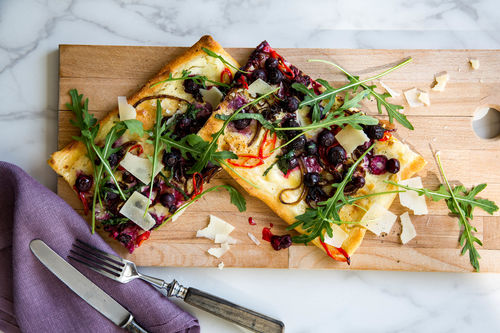 Zwiebel-Pizza mit Blaubeeren und Rucola