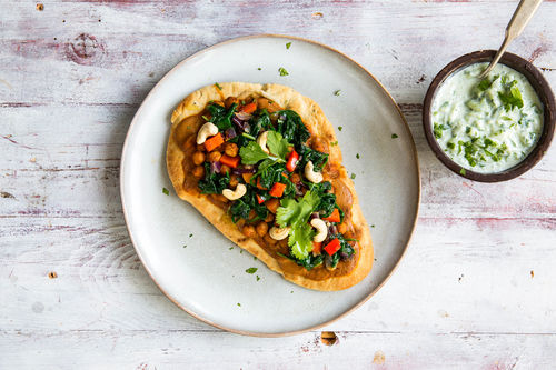 Pita-Pizza mit Kichererbsen dazu Tikka-Masala-Creme und Gemüse