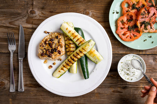 Schweinesteak mit Nusskruste auf Grillzucchini mit Tomatensalat