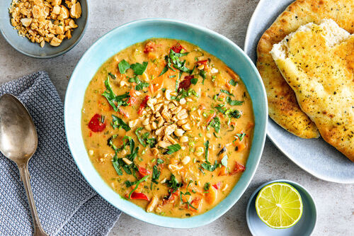 Bolivianische Erdnusssuppe mit frischen Kräutern und Knoblauch-Naanbrot