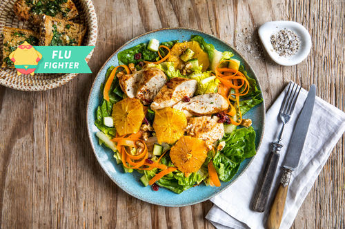 Orangenhuhn auf Wintersalat mit Cranberrys und Kräuterbaguette