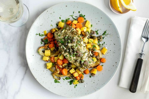 Im Ofen gebackener Seehecht mit buntem Röstgemüse, Kapern und Zitrone