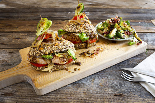 Schweinesteak-Tomaten-Sandwich mit Speck-Rosenkohl und Senfzwiebeln