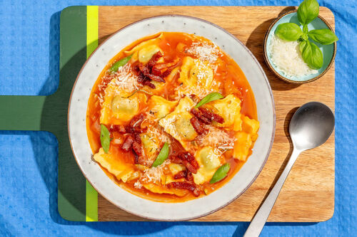 Tomatensuppe mit Speck & Tortelli garniert mit Käse und frischem Basilikum