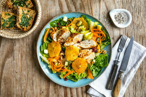 Orangenhuhn auf Wintersalat mit Cranberrys und Kräuterbaguette