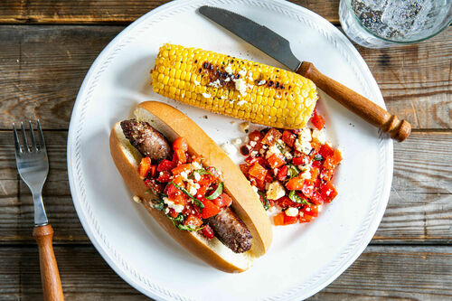 Hotdog mit Rindswurst und Feta dazu Paprikarelish und Mais mit Estragon