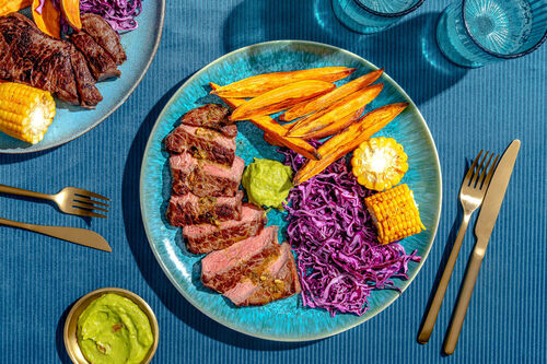 V2: Saftiges Bio-Rindersteak mit Orangensauce dazu Süßkartoffeln, Rotkohl und Cajun-Mais