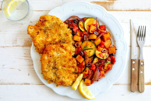 Knusprige Hähnchenschnitzel mit Kartoffeln in Tomatensugo