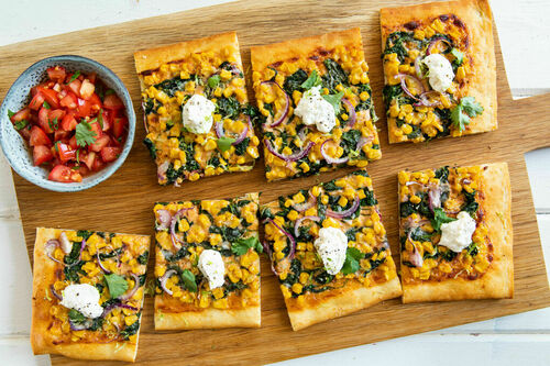Pizza mexicana mit Mais und Spinat mit würziger Käsecreme, dazu Tomatensalat