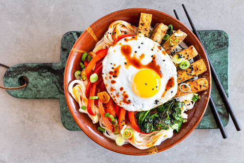 Vegetarische Udon Bibimbap-Style mit gebratenem Tofu und Spiegelei