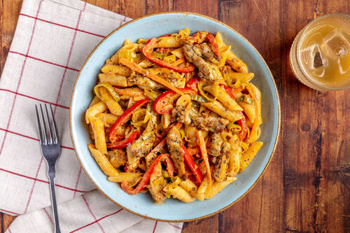 Penne mit zarten Hähnchenwürfeln in cremiger Pesto-Sauce mit Gemüse