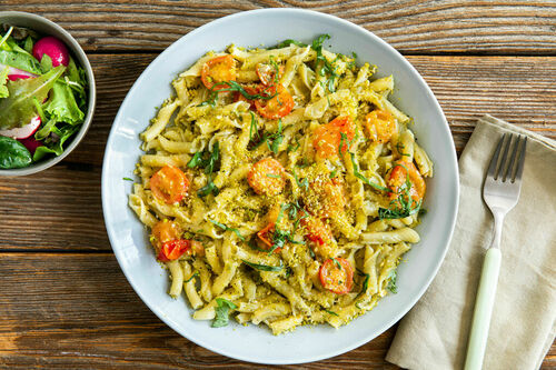 Pasta mit Kirschtomaten und Kapernpesto dazu Panko-Pistazien-Topping und Salat