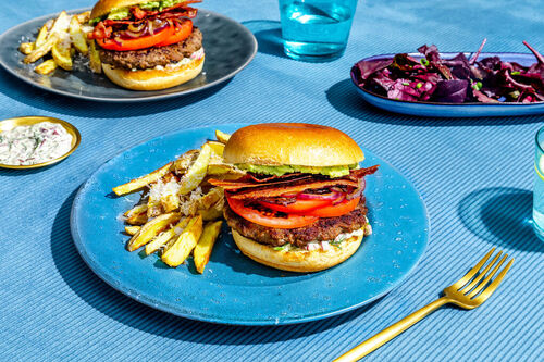 Rindfleisch-Bacon-Burger de luxe mit Käse-Trüffel-Pommes und Blattsenfsalat