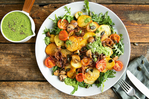 Bratkartoffeln und Gemüse auf Rucola mit Pesto-Dressing und Kürbiskernen