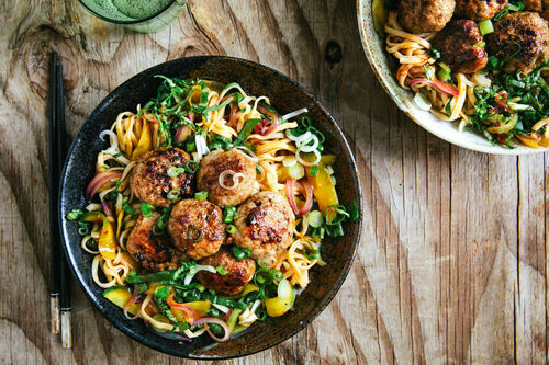 Asia-Hackbällchen mit Pak-Choi-Gemüse auf breiten Mie-Nudeln