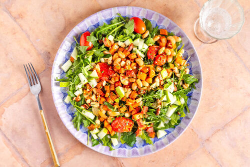 Chorizo-Bohnen-Salat mit Süßkartoffeln und Kirschtomaten auf Rucola und Apfel