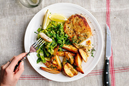 Paniertes Schweinerückensteak mit Backkartoffeln und Salat
