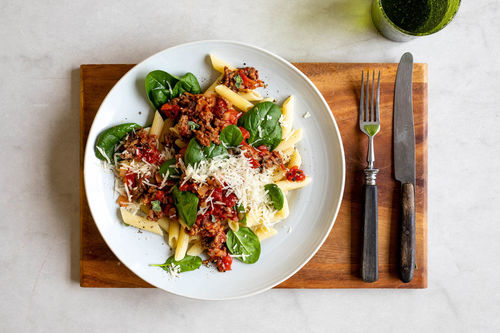 Penne mit Spinat-Bolognese und geriebenem Käse
