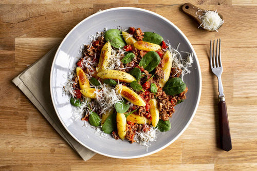 Bolognese-Schupfnudeln mit Spinat und geriebenem Käse