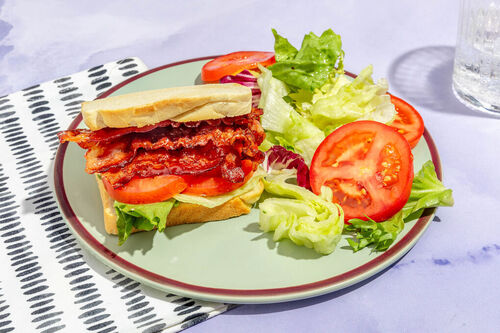 <650kcal: Bacon-Sandwich mit Ahornsirup garniert mit Tomate und buntem Salat