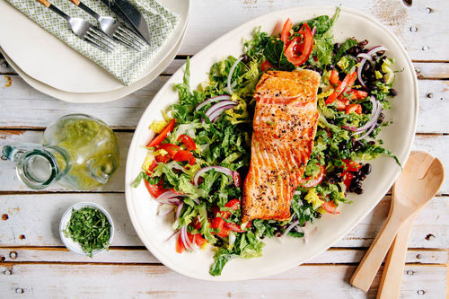 Gebratenes Lachsfilet auf buntem Salat mit Bohnen