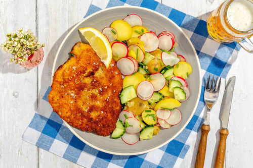 Schnitzel Wiener Art mit Zitrone und Kartoffelsalat mit Gurke und Radieschen