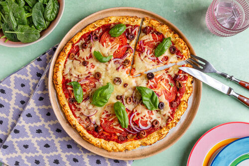 Blumenkohlreis-Pizza mit pikanter Tomatensauce, Oliven & Basilikum
