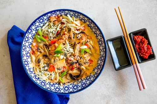 Bunte Asia-Nudelpfanne mit würziger Kokossauce und Sesam