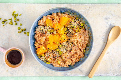 Raffinierter Milchreis mit Sesamstreuseln garniert mit Pistazien und Orange