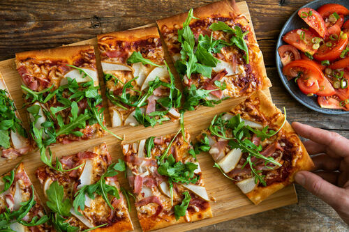 Rucola-Schinken-Pizza mit Birne dazu Tomatensalat