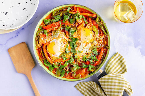 Shakshuka mit Hackfleisch und Ei mit bunten Paprika und Petersilie