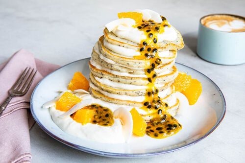 Passionsfrucht-Pancakes serviert mit Joghurt und Kokosflocken