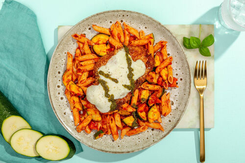 Hähnchen-Parmigiana auf Penne in Tomatensauce mit Karotten und Zucchini